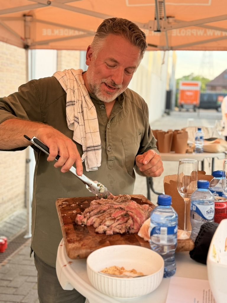 Chef snijdt gegrild vlees aan voor de deelnemers