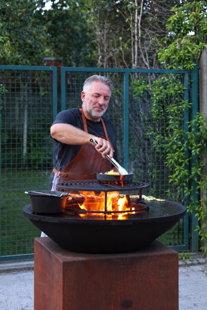 Chef kookt boven open vuur op een OFYR-grill